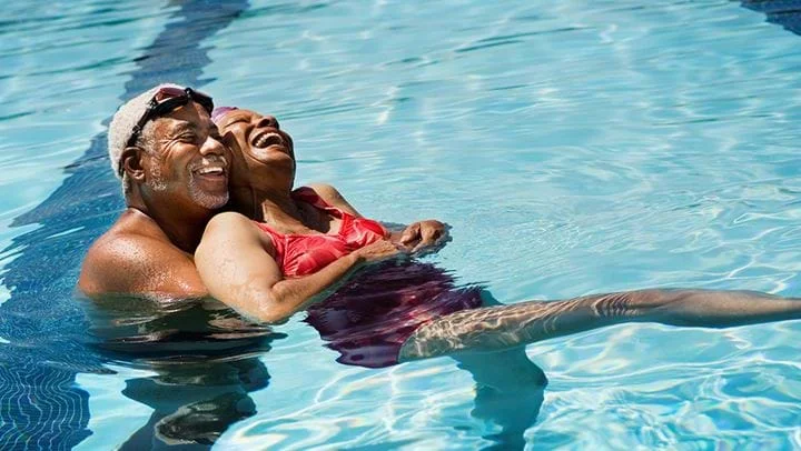 Ein Mann in einem Tümpel hält einen Fisch in der Hand