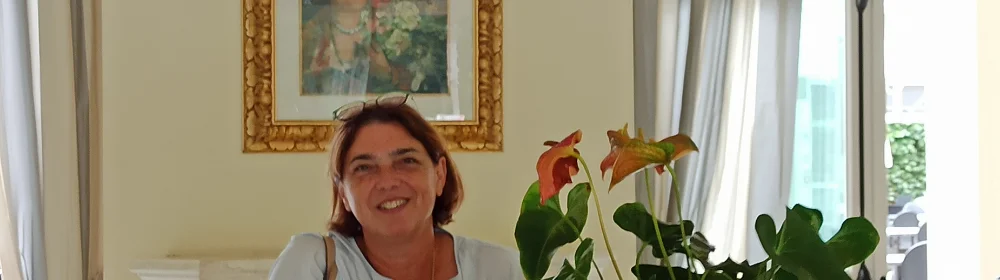 植物を前にして微笑む女性