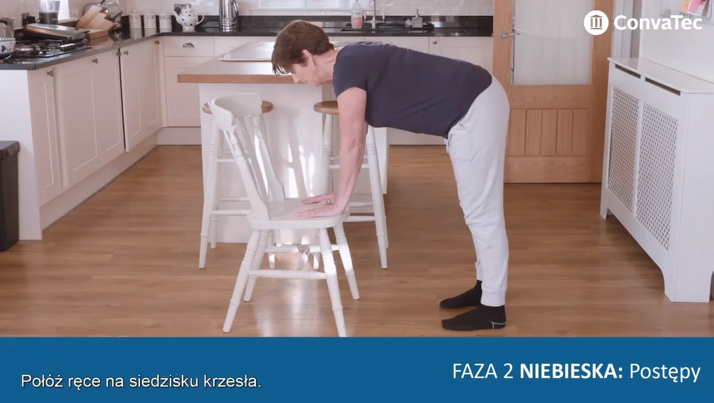 osoba pochylająca się nad krzesłem